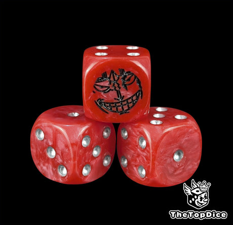 Close up of a red 16mm resin D6 die engraved with a black pirate emblem and silver pips