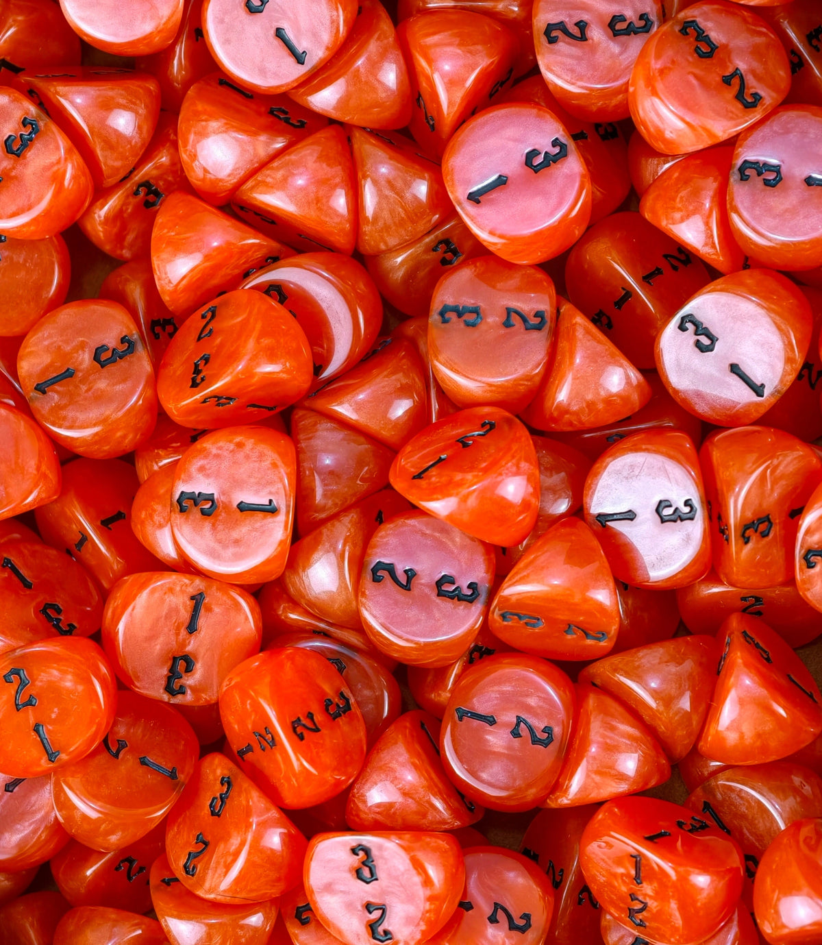 Neon red three sided dice covering a tray, numbering facing the camera