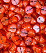 Neon red three sided dice covering a tray, numbering facing the camera