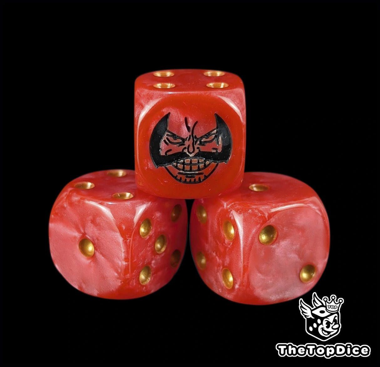 Close up of a red 16mm resin D6 die engraved with a black pirate king emblem and gold pips