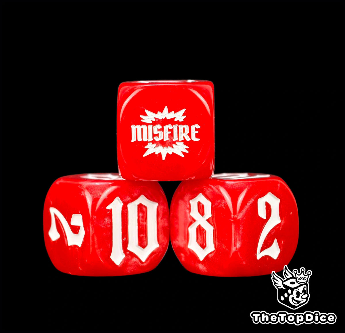 Four marbled red 16mm dice close up, the MISFIRE burst sitting above the 10 and 8