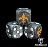 Close-up of a black D6 die with a gold lily emblem