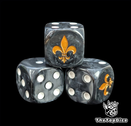 Close-up of a black D6 die with a gold lily emblem