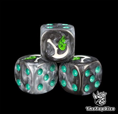 Close up of a black 16mm resin D6 die engraved with a white scythe trailing green flame