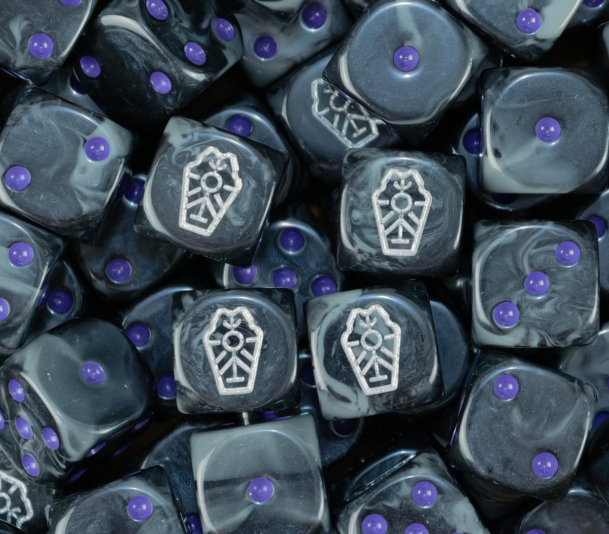 Pile of Necron dynasty dice in black and grey with silver glyphs and purple pips