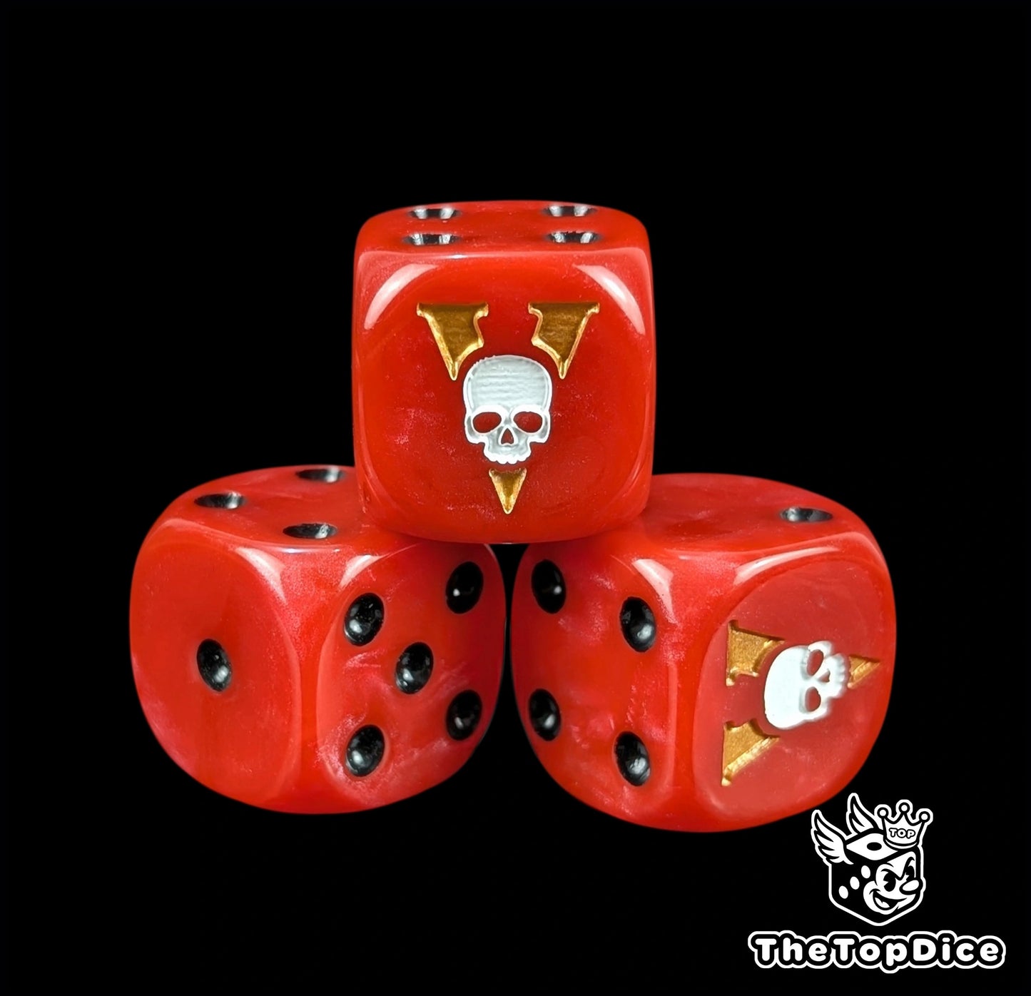 Dados inspirados en los vostroyan de warhammer de base de color rojo con puntos de color negro y el logo es una calavera blanca atravesada por una V de vostroyan de color dorado