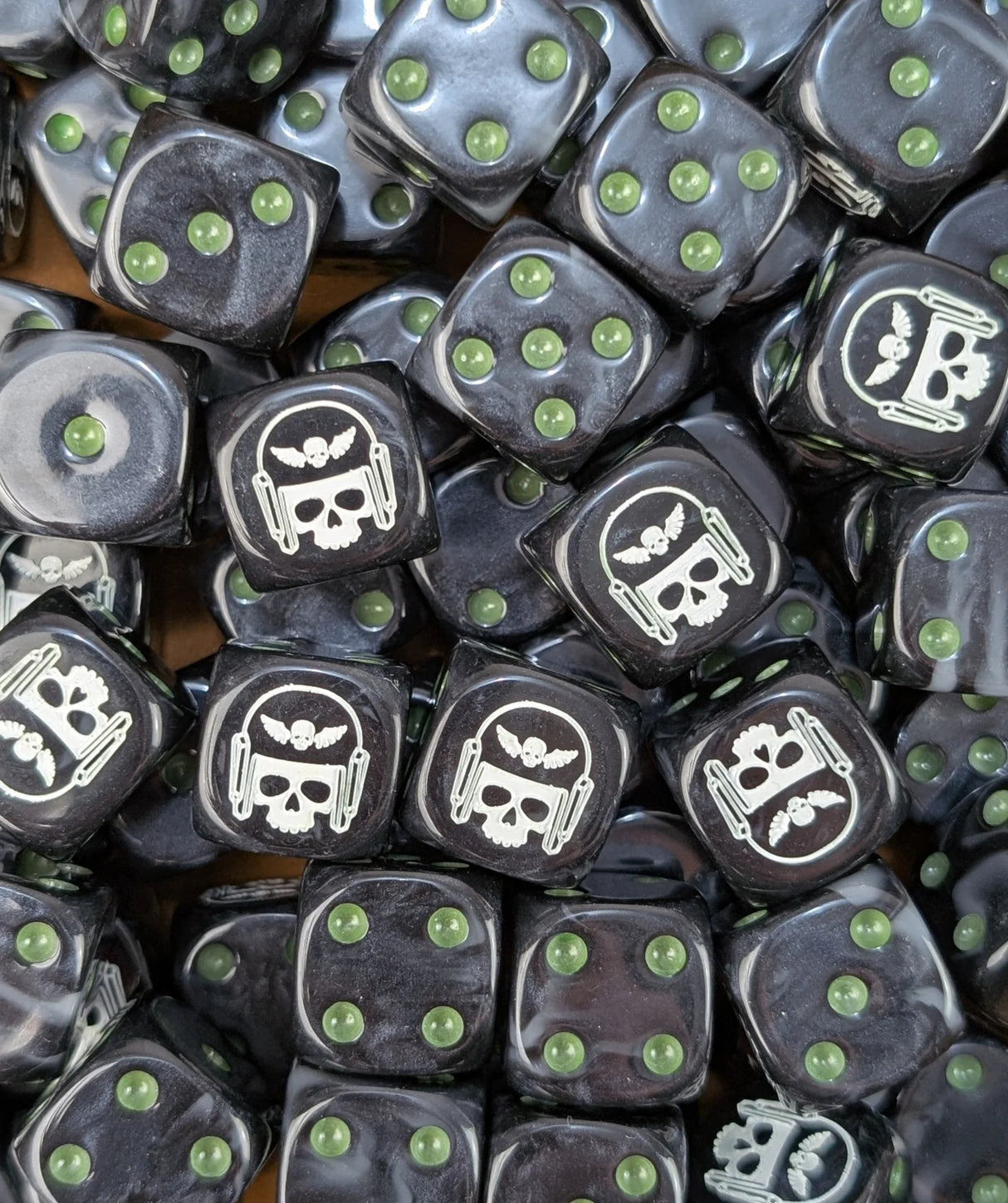 Pile of black and grey winged skull 16mm D6 dice for a sci-fi guard army