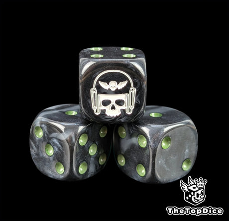 Close up of a black and grey 16mm resin D6 die engraved with a white winged skull in a helmet and green pips