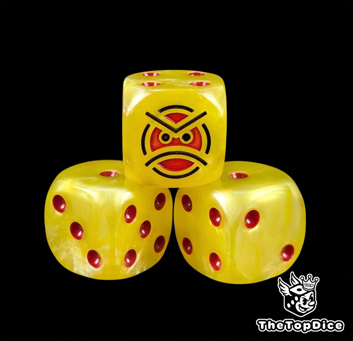 Close up of a yellow 16mm resin D6 die engraved with a red angry face and red pips