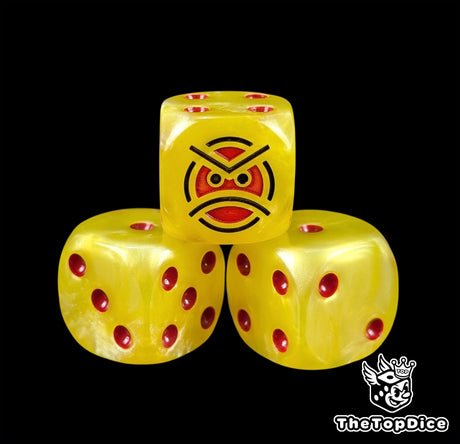 Close up of a yellow 16mm resin D6 die engraved with a red angry face and red pips