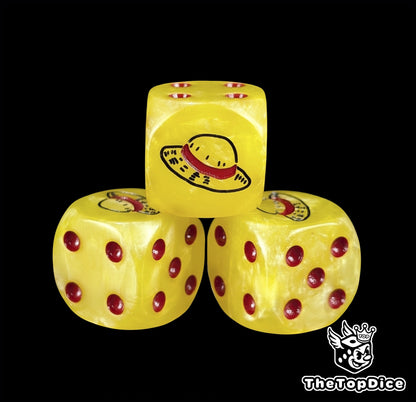 Close up of a yellow 16mm resin D6 die engraved with a black straw hat emblem and red pips