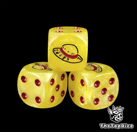 Close up of a yellow 16mm resin D6 die engraved with a black straw hat emblem and red pips