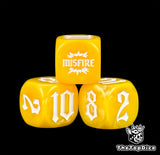 Yellow 16mm dice photographed close, four of them, MISFIRE resting on the 10 and the 8
